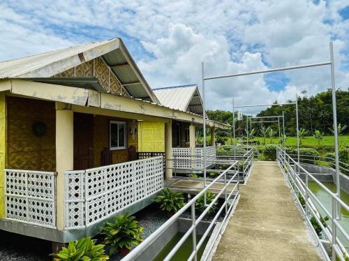 a yellow house with a white fence around it at Jazz Ferme Inn Batuan Bohol in Batuan