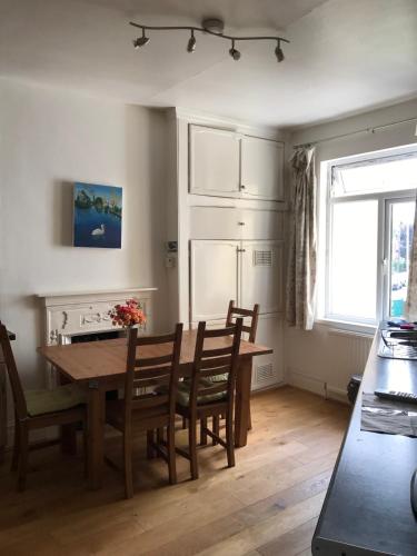 uma cozinha com uma mesa e cadeiras e uma cozinha com uma janela em Spacious 3 Bed Room Flat in South West London em Londres