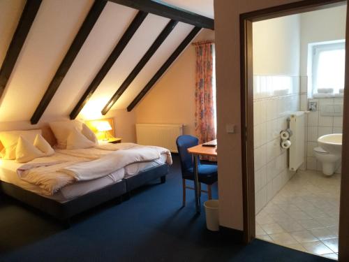 普萊藤貝格的住宿－Hotel Klinger，一间带一张床和一张书桌的卧室以及一间浴室。