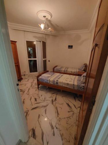 1 dormitorio con 2 camas y suelo de mármol en Appartement S2 Kantaoui vue mer en Port El Kantaoui