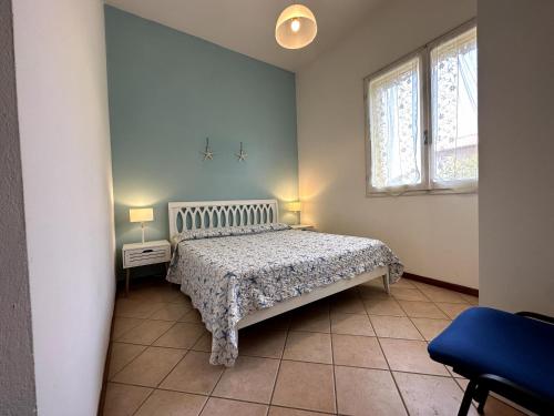 a small bedroom with a bed and a window at Delta Blu Residence Village in Lido di Pomposa