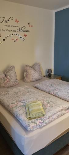 a bed with a blanket on top of it at Ferienwohnung Bergidyll in Schwarzenberg (Erzgebirge)