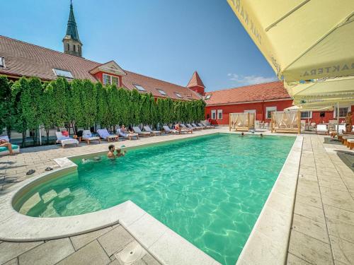 a large swimming pool with a person in the water at Kaštel Ečka in Ečka