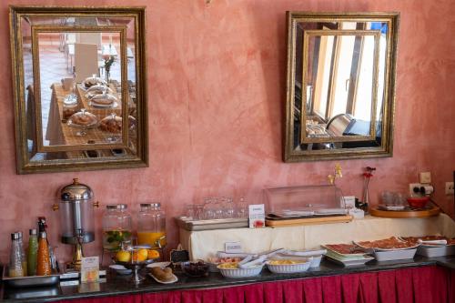 a buffet with two mirrors and food on a table at Hotel Rural Spa Don Juan de Austria in Jarandilla de la Vera