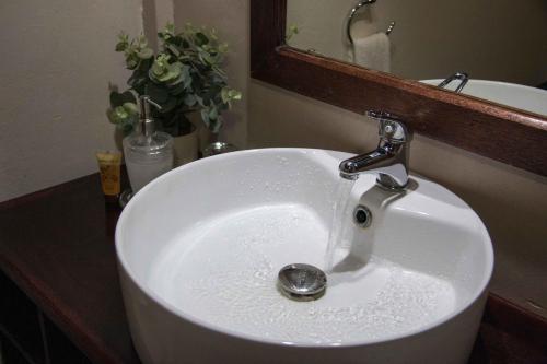 a white sink with a faucet in a bathroom at Zoete Rust Boutique Hotel in Lephalale