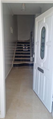 um corredor vazio com uma porta branca e escadas em Familie appartement Alhoceima em Ajdir