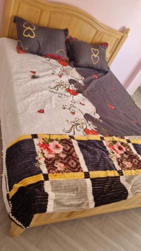 łóżko z kołdrą i poduszkami w obiekcie Familie appartement Alhoceima w mieście Ajdir