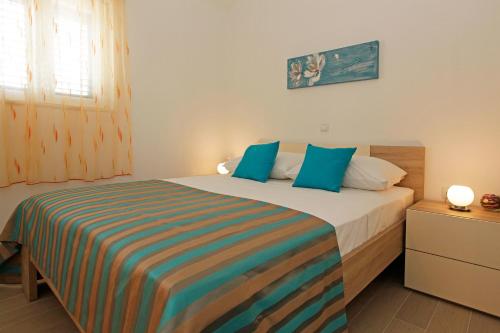 una camera da letto con un grande letto con cuscini blu di Robinzon Villa Zavala a Povlja