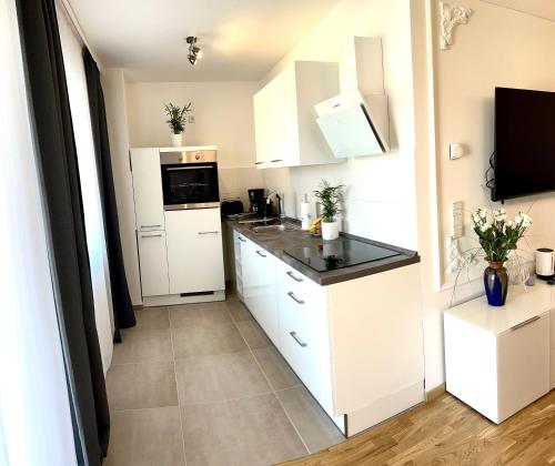 eine Küche mit weißen Schränken und schwarzen Arbeitsplatten in der Unterkunft Leon Art Apartment in Leipzig