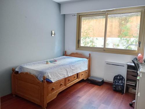 ein Schlafzimmer mit einem Holzbett und einem Fenster in der Unterkunft Résidence de Croisset in Grasse
