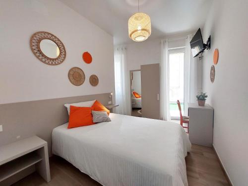 um quarto com uma grande cama branca com almofadas laranja em Affittacamere Casa Lilibet em San Benedetto del Tronto