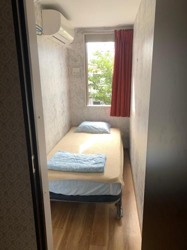a small room with two beds and a window at Tokyo Guest House 2020 in Tokyo
