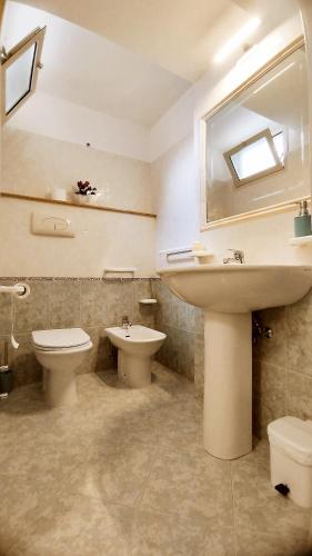 a bathroom with a sink and a toilet and a mirror at Casa alla Costa in Mormanno