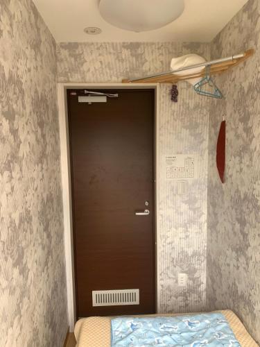 a door in the corner of a room with a bed at Tokyo Guest House 2020 in Tokyo