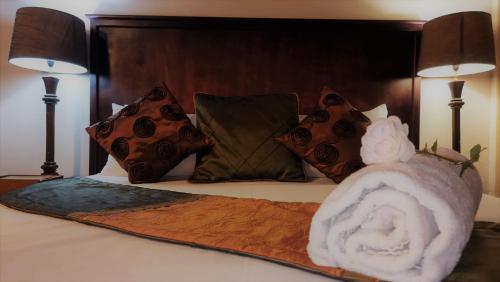 a bed with a blanket and pillows and a towel at Zoete Rust Boutique Hotel in Lephalale