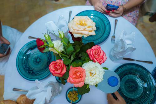 a white table with a vase of flowers on it at Riad Dar Zaouia in Marrakech