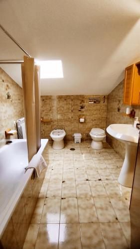 a bathroom with two toilets and a tub and a sink at Casa alla Costa in Mormanno