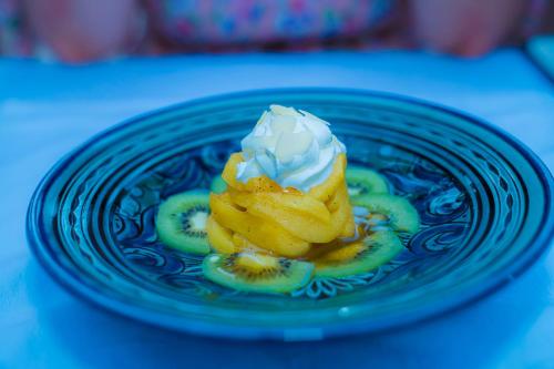 a blue plate with a dessert with kiwi and whipped cream at Riad Dar Zaouia in Marrakech