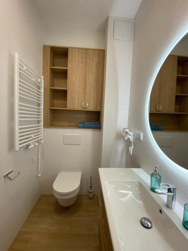 a bathroom with a toilet and a sink and a mirror at Bel Mare Aqua Resort 508 in Międzyzdroje