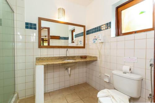 a bathroom with a toilet and a sink and a mirror at Pousada Villa Bianca in Arraial d'Ajuda