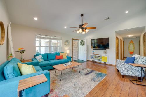 Una sala de estar con un sofá azul y sillas. en Eufaula Oasis with Screened Porch Unwind in Style!, en Eufaula