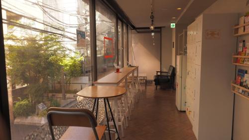 a bar with a table and chairs in a room at bnb+ Secret Base Mejiro in Tokyo