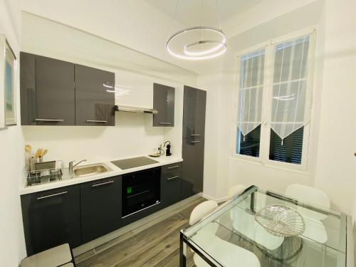 - une cuisine avec un évier et une table en verre dans l'établissement Cozy 2 bedroom apartment in the centre of Cannes near the CROISETTE, à Cannes