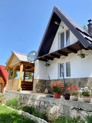 een huis met een schuin dak en een veranda bij Vikendica Amra i Indir in Travnik