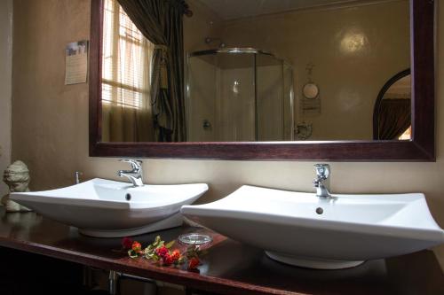 a bathroom with two sinks and a large mirror at Zoete Rust Boutique Hotel in Lephalale