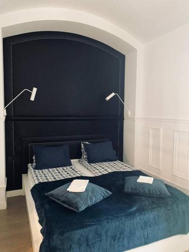 a large black bed with two pillows and two lamps at Lux apartment near Wawel in Krakow