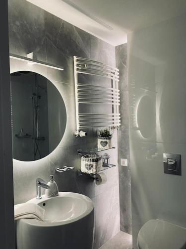 a bathroom with a sink and a mirror and a toilet at Lux apartment near Wawel in Krakow
