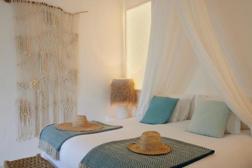 a bedroom with two beds with straw hats on them at Octant Vila Monte in Moncarapacho
