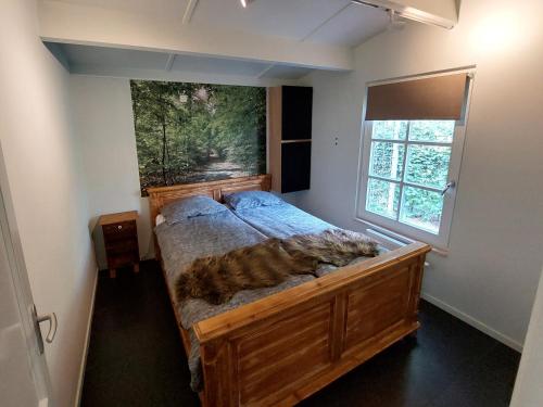 a large bed in a room with a large window at Villa Mar veluwe in Ermelo