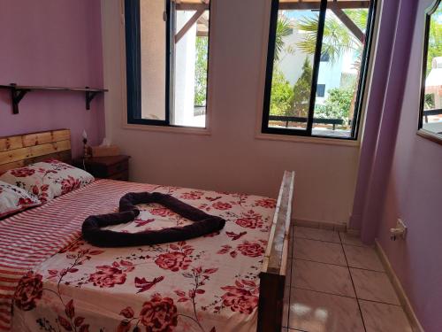 1 dormitorio con 1 cama con manta roja y ventanas en Palm garden paradise, en Perivolia