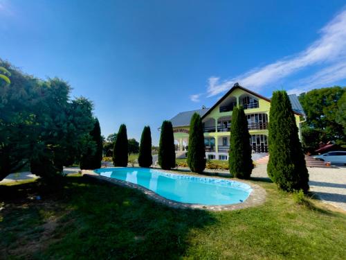 a resort with a swimming pool in front of a building at Pensiunea Victoria Sambata de Sus in Sîmbăta de Sus