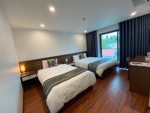 een hotelkamer met 2 bedden en een raam bij Apricot Garden Hotel in Sa Pa