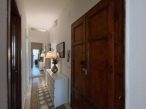 a hallway with a door and a vase on a dresser at La Casa di Eli Appartamenti in Pisa