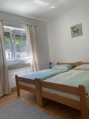 a bedroom with two beds and a window at Guesthouse Abrlic in Seliste Dreznicko