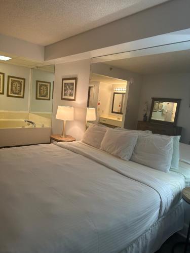 um quarto com uma grande cama branca e um espelho em River Place Condos #409 1BD, 2Bath em Pigeon Forge