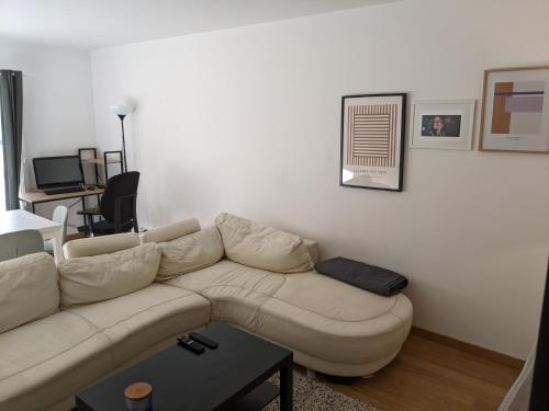 a living room with a white couch and a table at Appartement SQY in Guyancourt