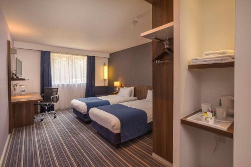 a hotel room with two beds and a desk at Holiday Inn Express Preston South by IHG in Preston