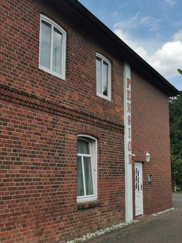 a brick building with a sign on the side of it at Pension zum Park in Goldberg