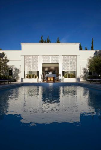 a white building with a swimming pool in front of it at Octant Vila Monte in Moncarapacho
