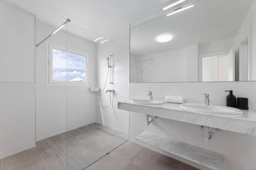 プラヤ・ブランカにあるOcean views and relax in Lanzaroteの洗面台2つとシャワー付きの白いバスルーム