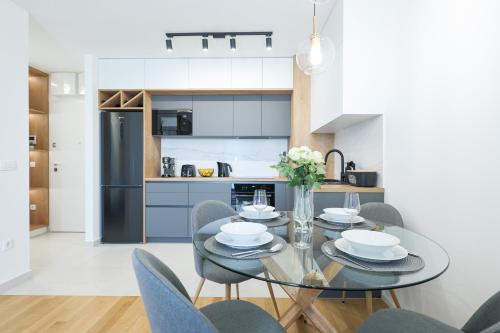 eine Küche und ein Esszimmer mit einem Glastisch und Stühlen in der Unterkunft Alpha Level Apartment in Zadar