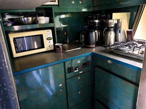 a kitchen with a stove and a microwave at Hotel Autokar Kamper 2 pietrowy, kuchnia, wc, kapsuly sypialne in Jastarnia