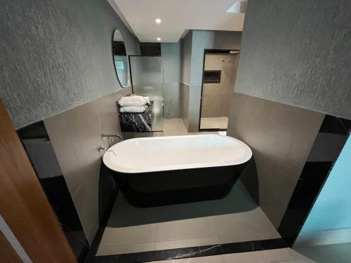 a bathroom with a bath tub and a mirror at HOTEL PORTELÃO in Rio de Janeiro