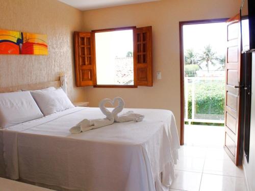 雅帕拉廷加的住宿－Pousada Badejo，一间卧室配有一张带两个天鹅的床