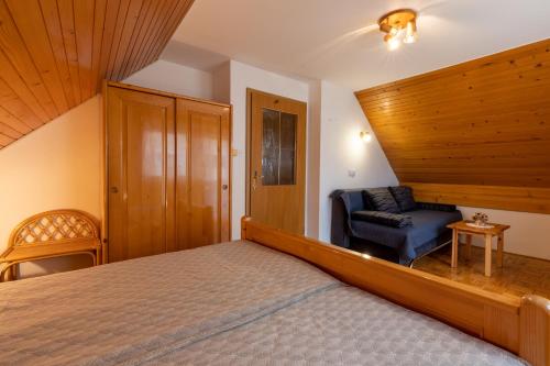 um quarto com uma cama e uma cadeira em Apartment Vidmar em Bohinj