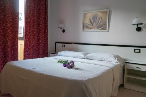 a bedroom with a white bed with flowers on it at Hotel Italia in Porretta Terme